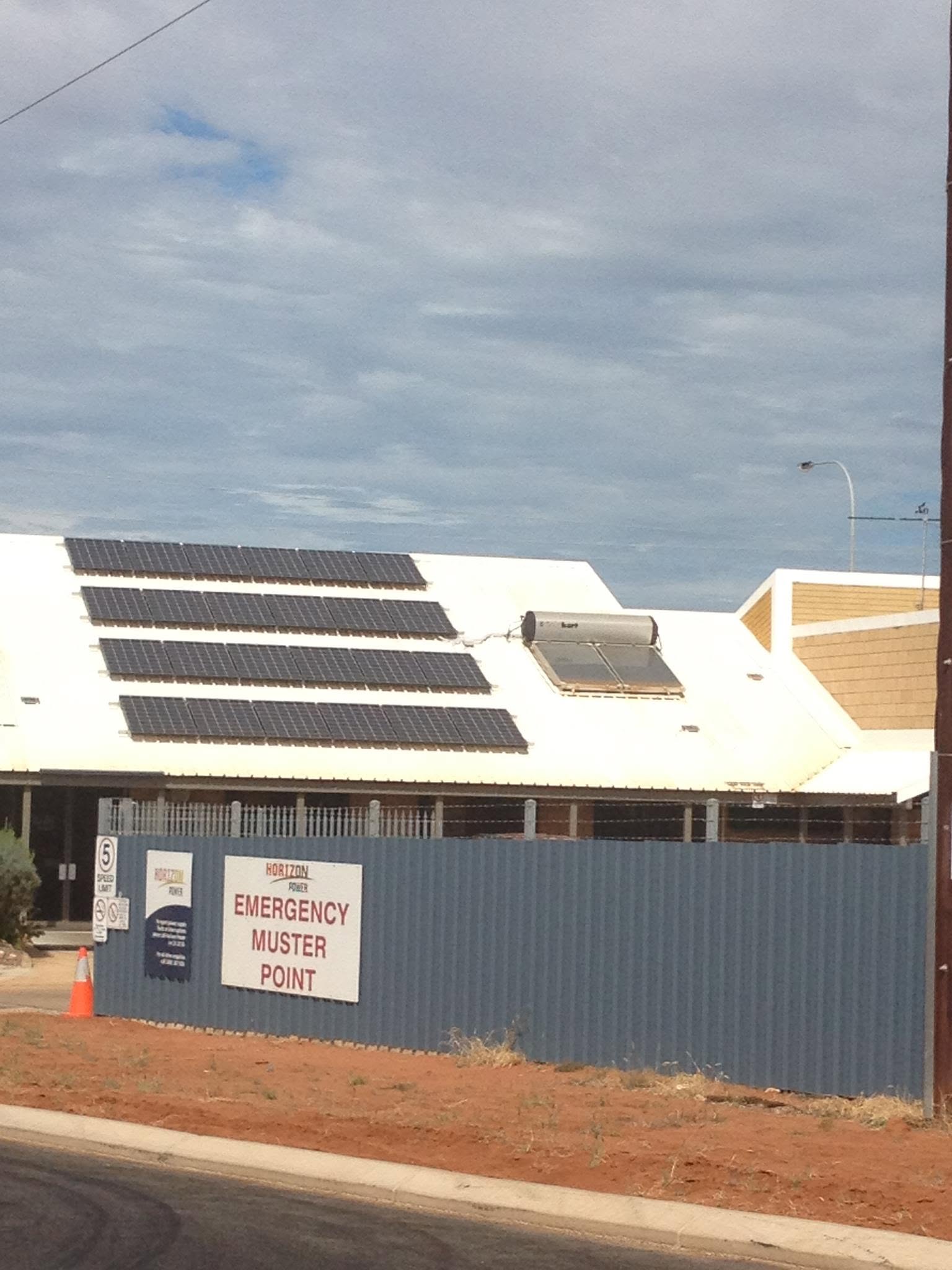 Solar panels on a shed roof at a regional site with red earth.